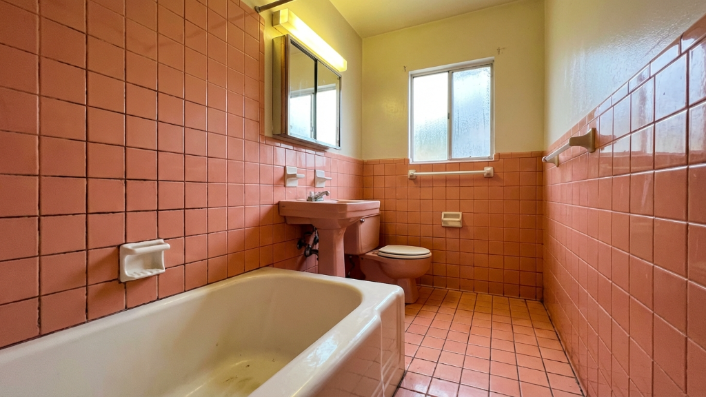Outdated bathroom with pink tile walls and fixtures
