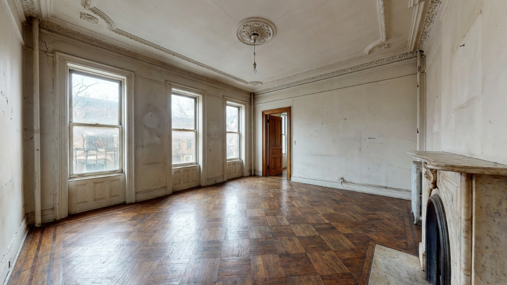 Empty parlor with ornate ceiling medallion and marble fireplace