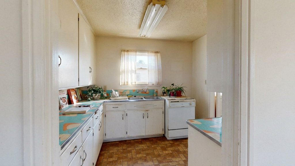Tired kitchen with retro patterned countertops and white cabinets